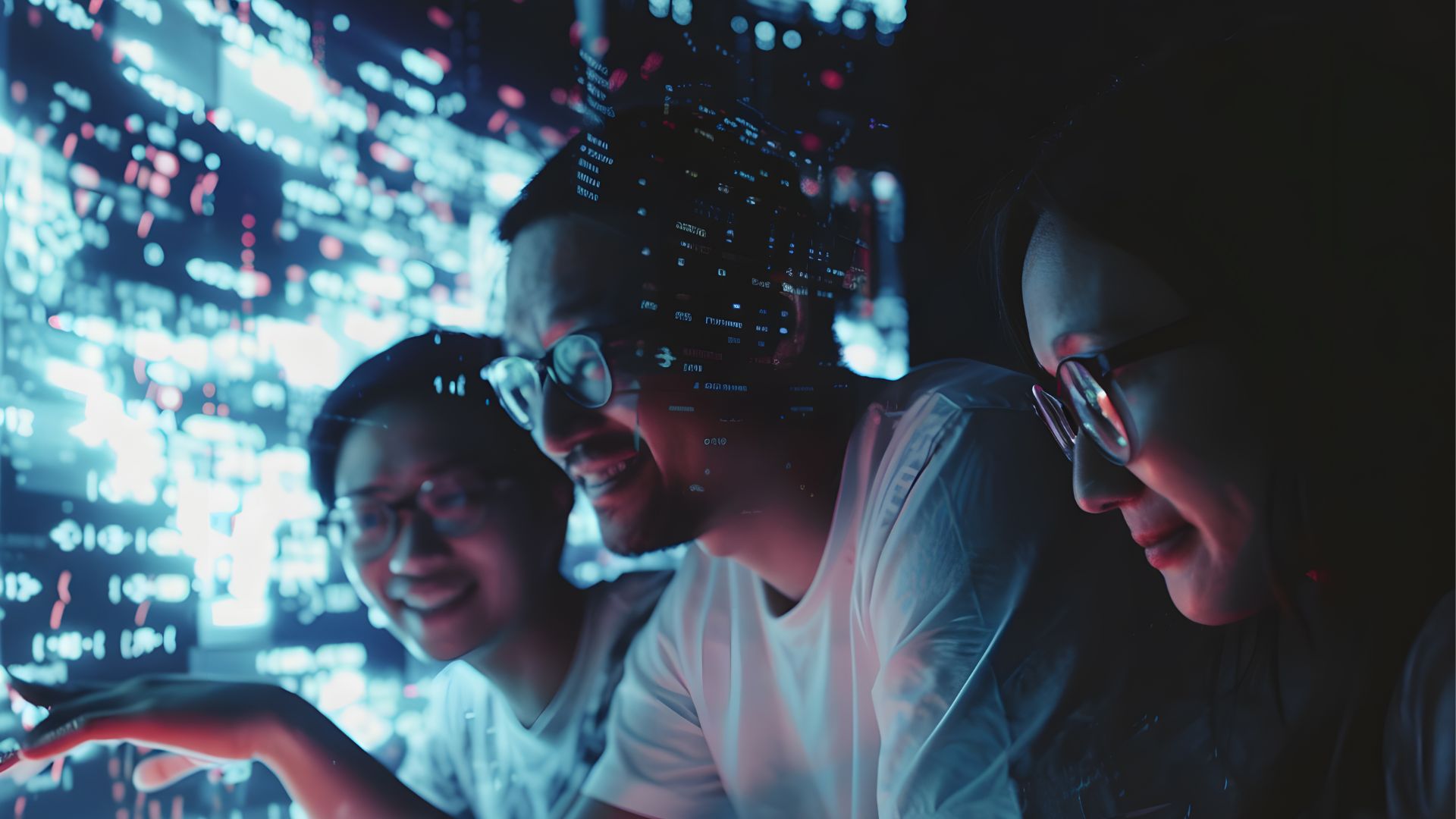 Tre persone lavorano insieme davanti a un grande schermo