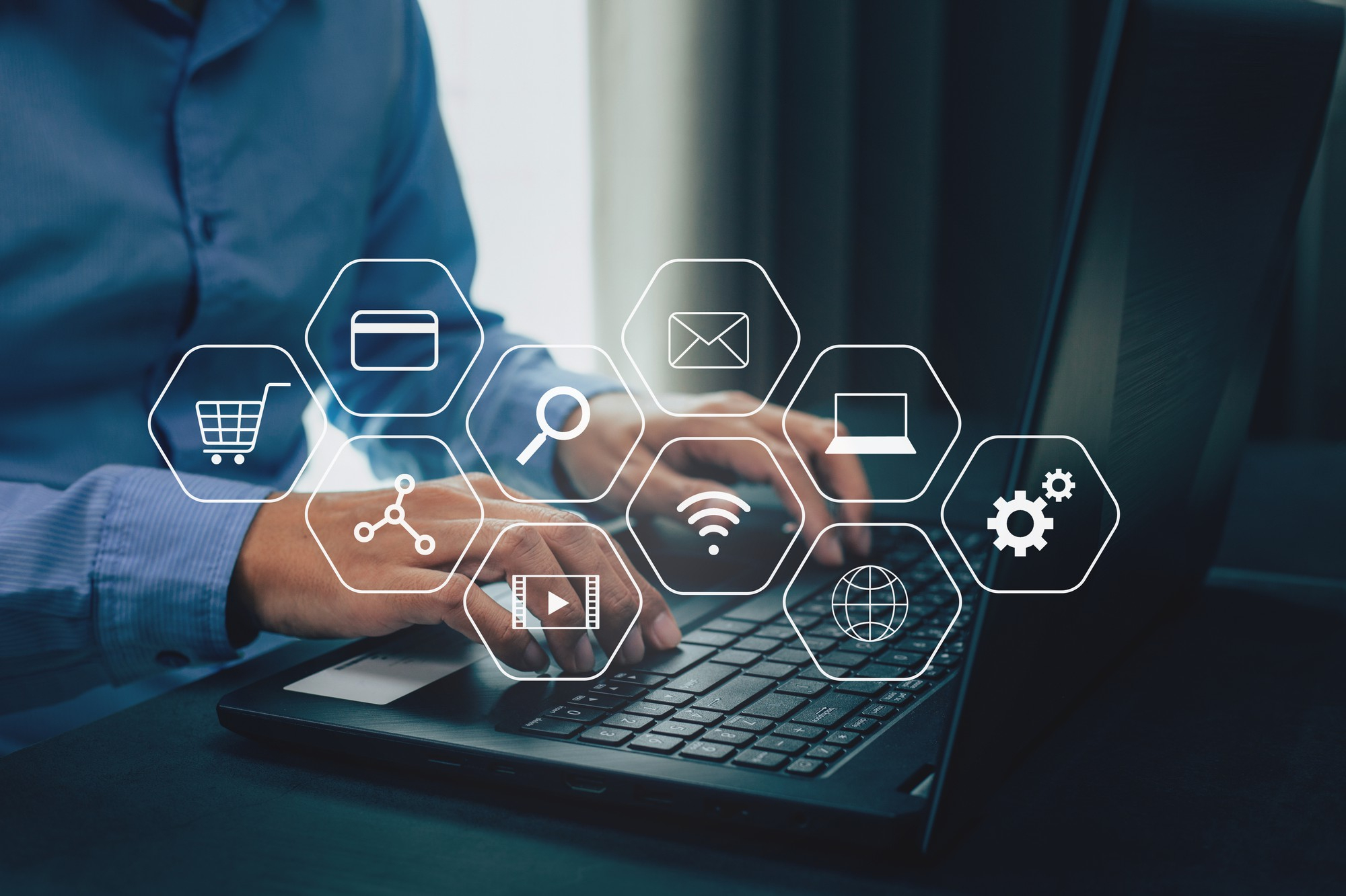 Uomo che lavora su tastiera PC con icone di vari servizi